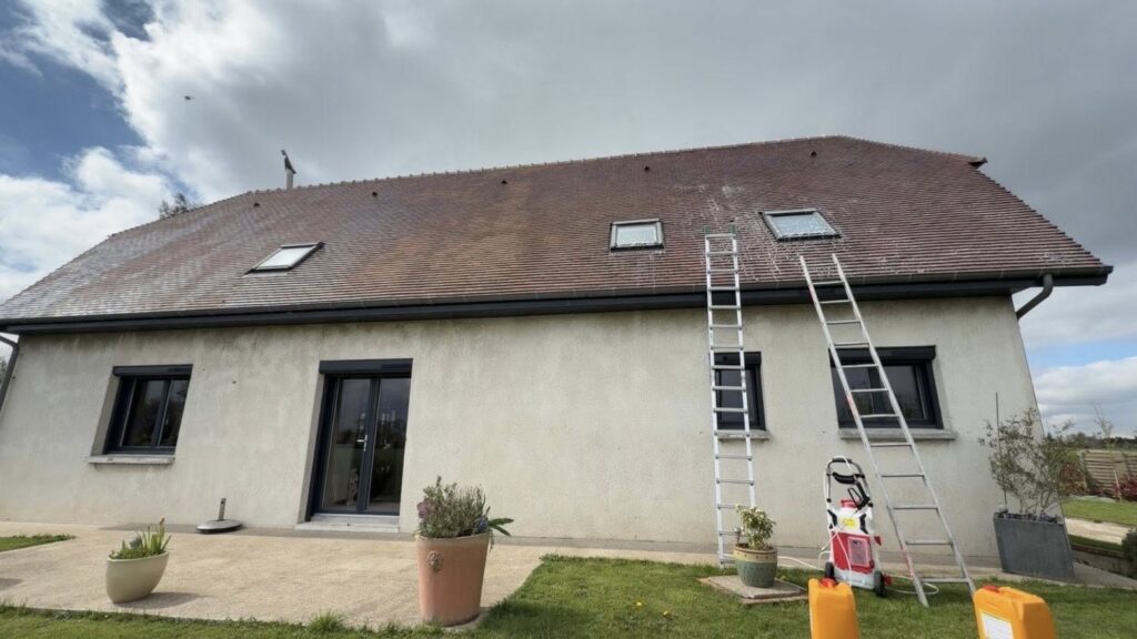 Maison crépie avec toiture en tuiles encrassées avant démoussage et traitement anti-mousse