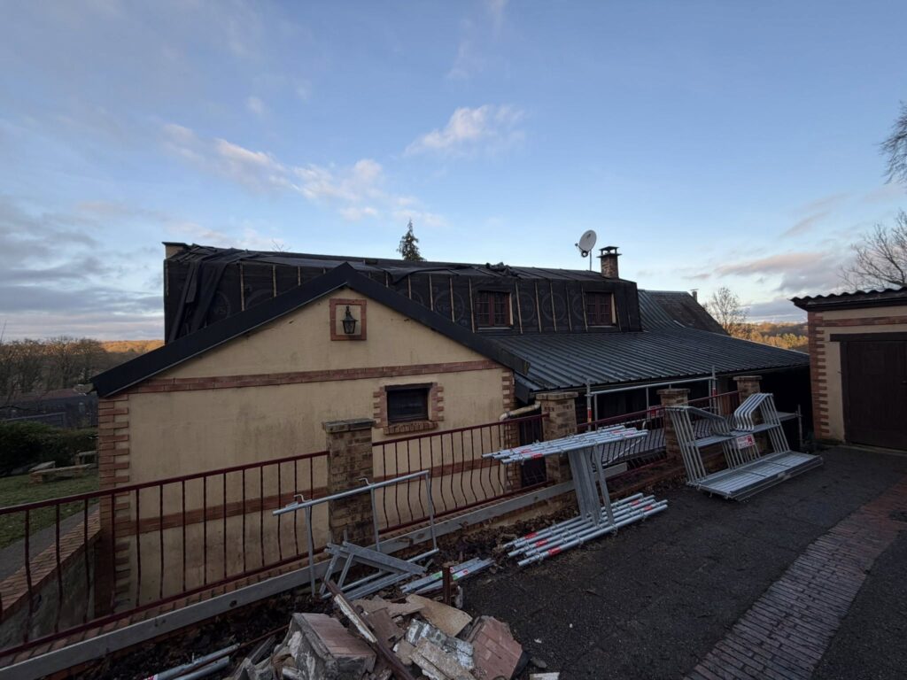 Toiture longère en cours de rénovation avec bâche noire de protection et échafaudage